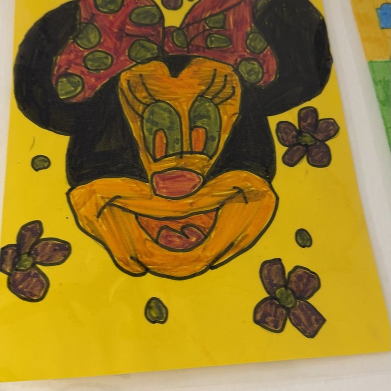 A painted Minnie Mouse portrait with a red bow on a yellow background