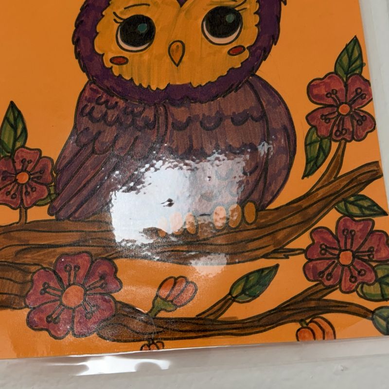 A painted owl perched on a flowering branch against a warm orange background