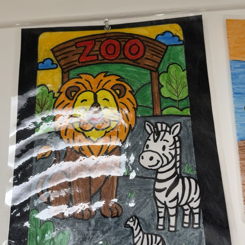 A painted zoo scene with a lion and zebra beneath a red ZOO archway
