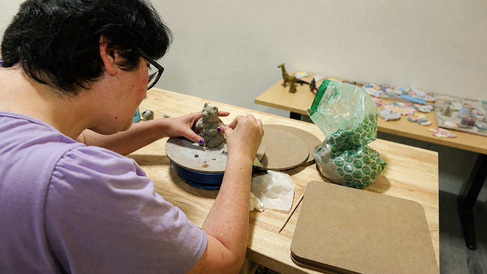 A participant shaping a clay figure during pottery class
