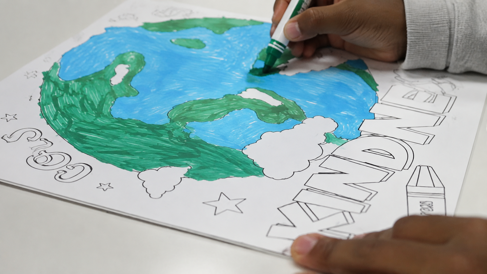 A participant creating a colorful earth-themed art project