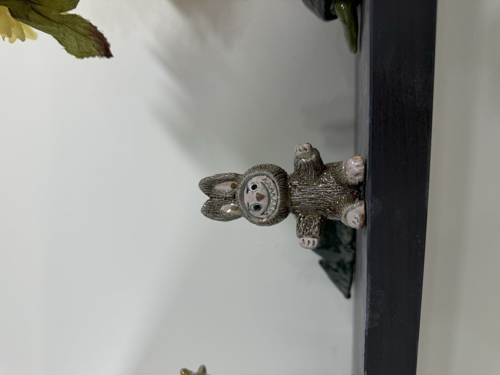 A small hand-sculpted clay rabbit with a painted face