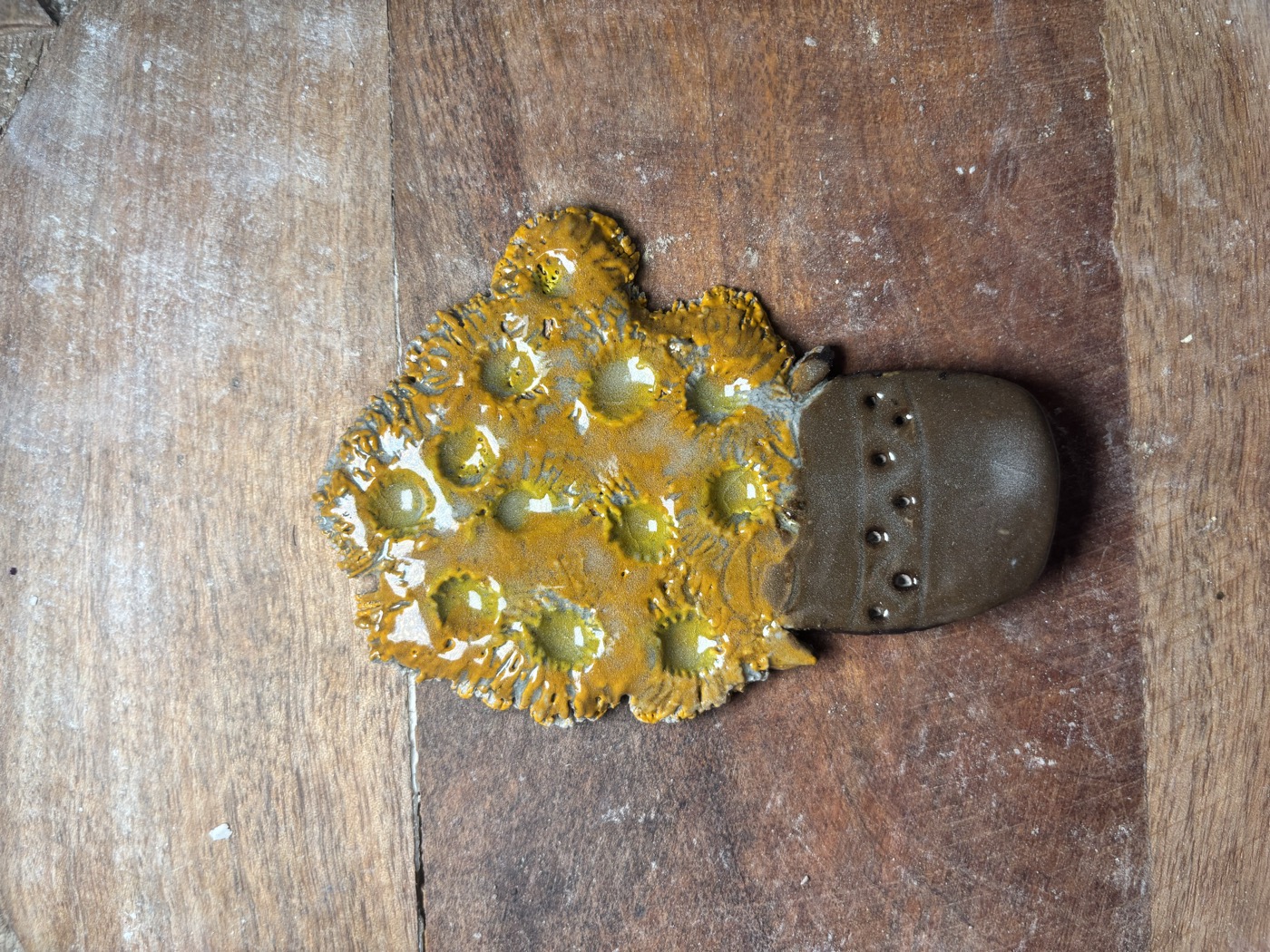 Clay flower pot with golden blooms, shaped and painted in class