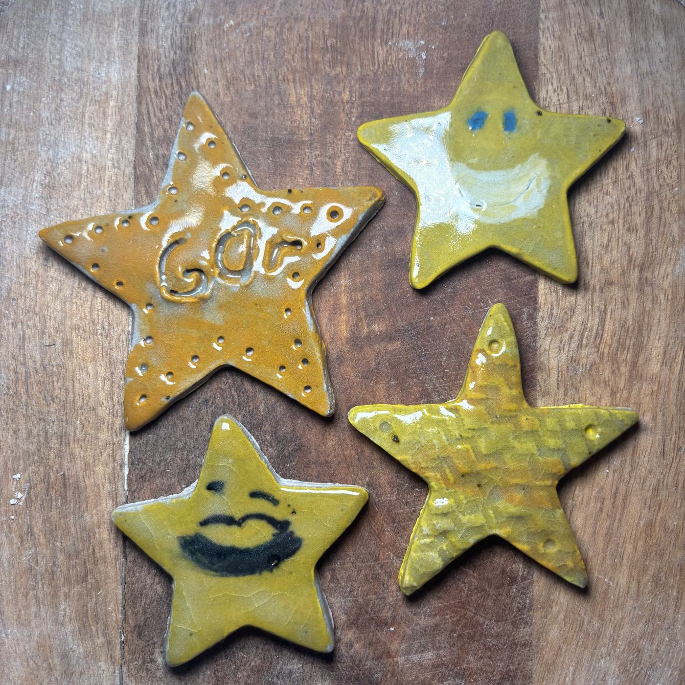 Smiling clay stars painted gold and pink