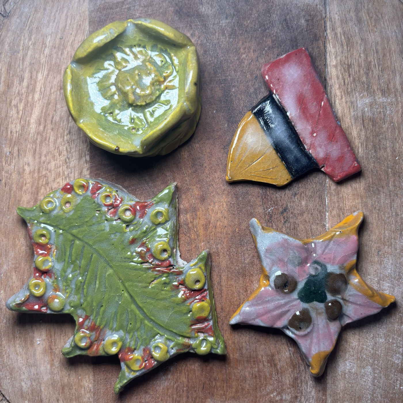 Clay leaf, star, and fan pieces, painted in class