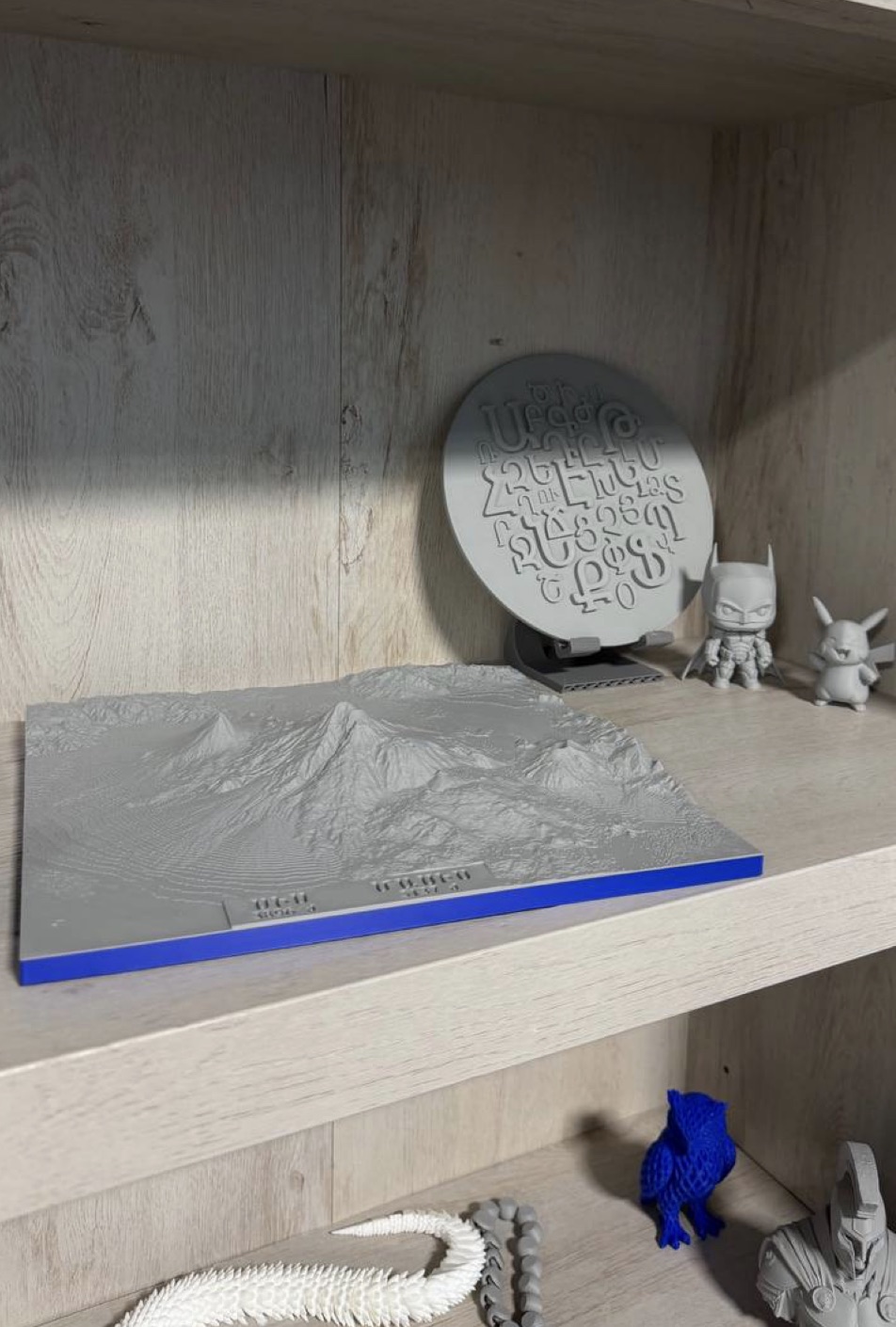 3D-printed pieces made by children in the SAI Connections computer lab, including a relief model of Mount Ararat, a disc of the Armenian alphabet, and printed figurines