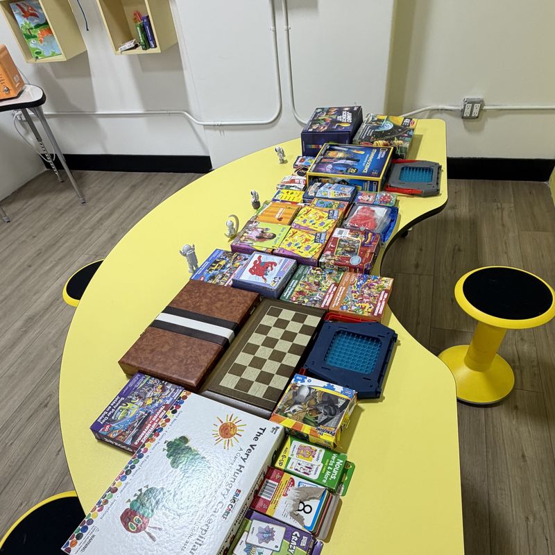 The games table at the SAI Connections Van Nuys center laid out with board games, card games, puzzles and a chess set, ready for a social skills session