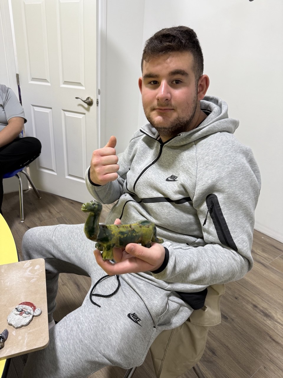An adult proudly holding a clay creation during pottery in Van Nuys