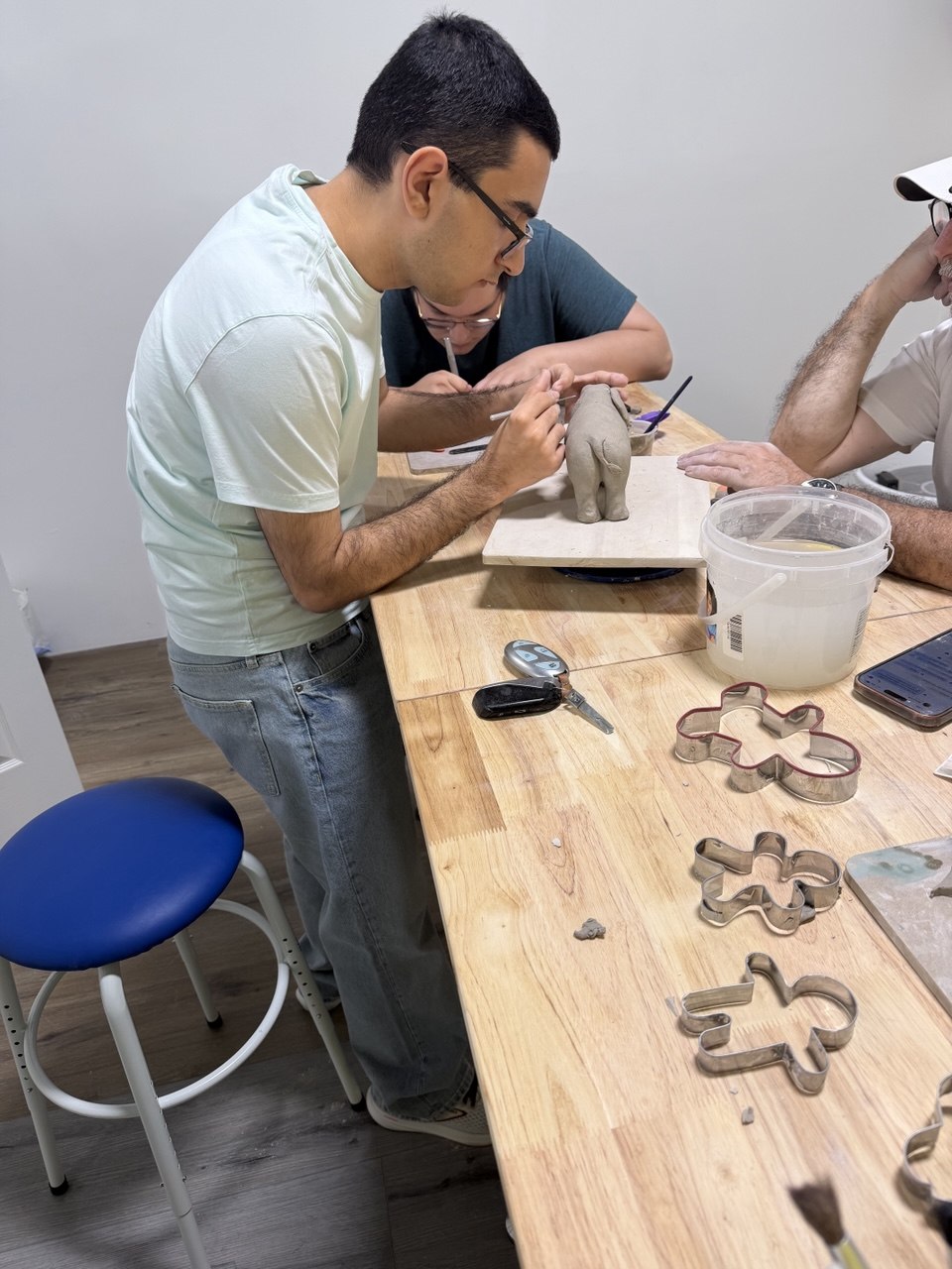 An adult sculpting clay at the Van Nuys pottery table