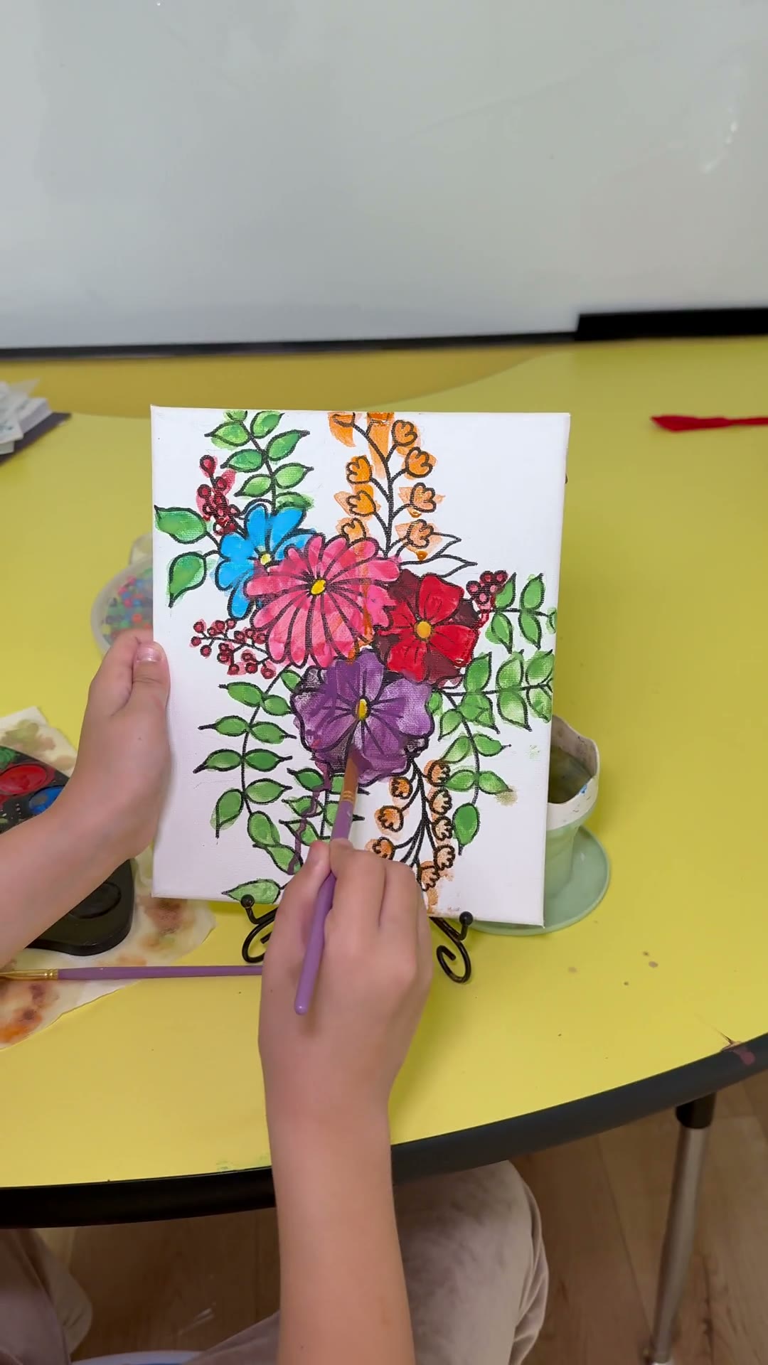 Child painting a flower bouquet at a sensory-friendly art class in Glendale