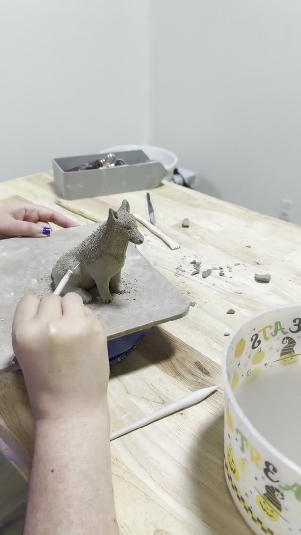 Sculpting and painting clay at the Van Nuys pottery table, with finished pieces drying nearby